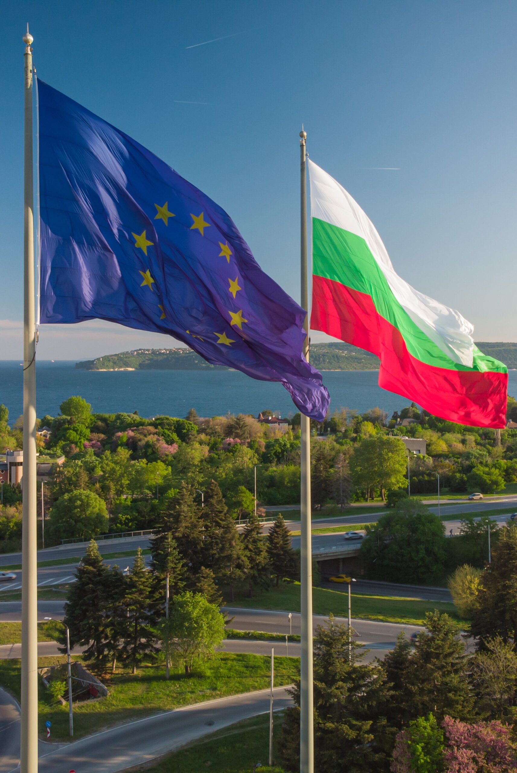 European Union and Bulgaria flags Against City Varna and blue sky at summer day