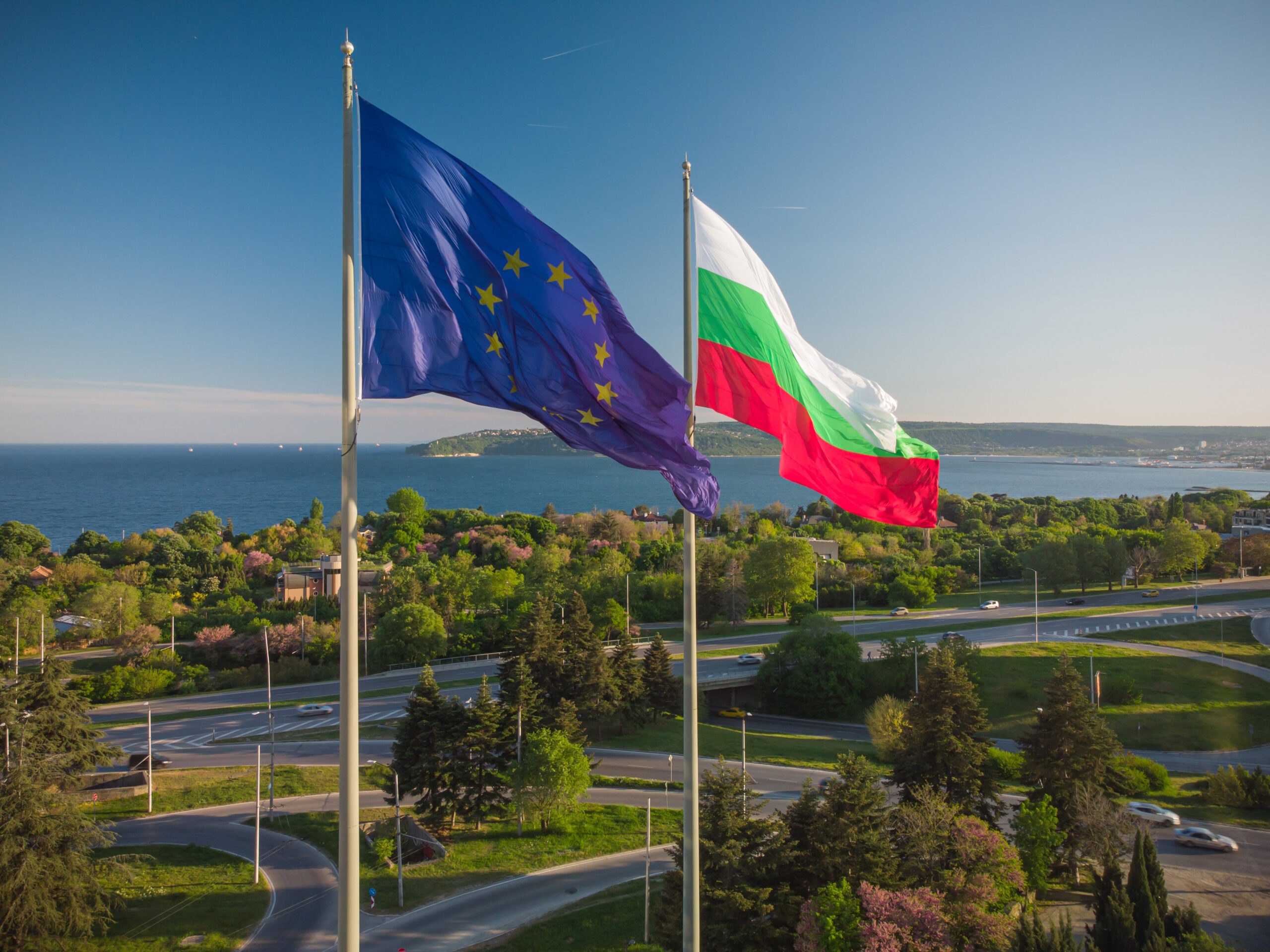 European Union and Bulgaria flags Against City Varna at summer day